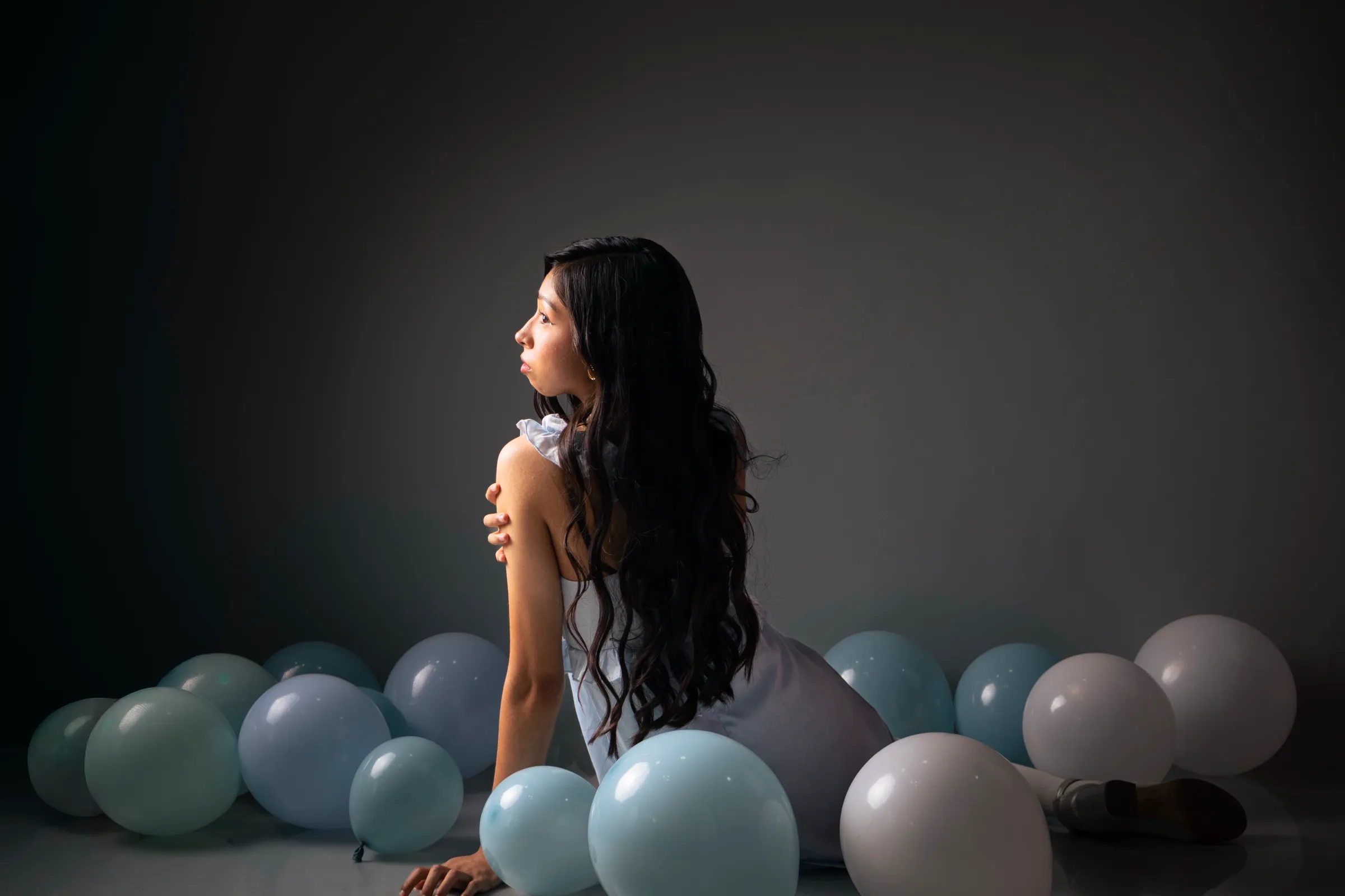 Libni de espaldas entre globos, luz lateral